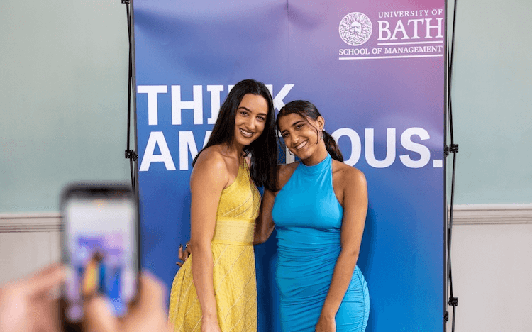 Mastering entrepreneurship management can be challenging, which is why many students choose to go to business school. Image: two female students at a graduation ceremony ©Bath School of Management